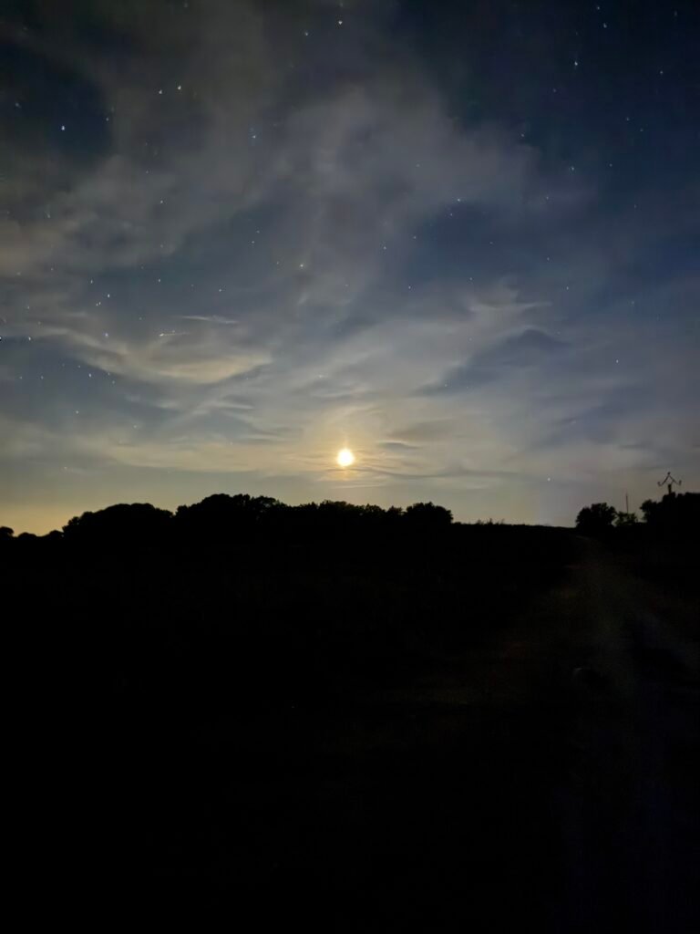 Ciel de nuit voilé, lueur de la lune sur la campagne