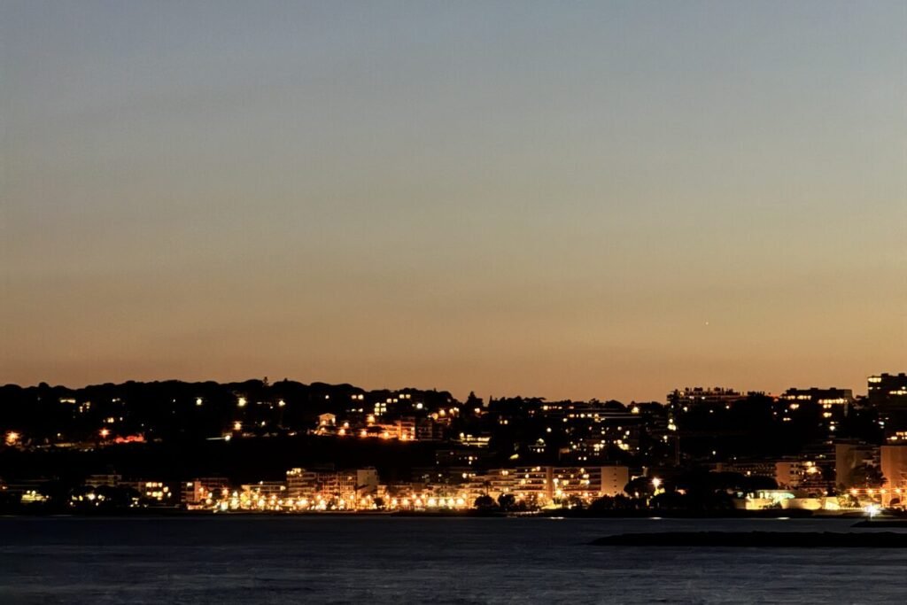 Lumières d'une ville au bord de l'eau à la tombée de la nuit